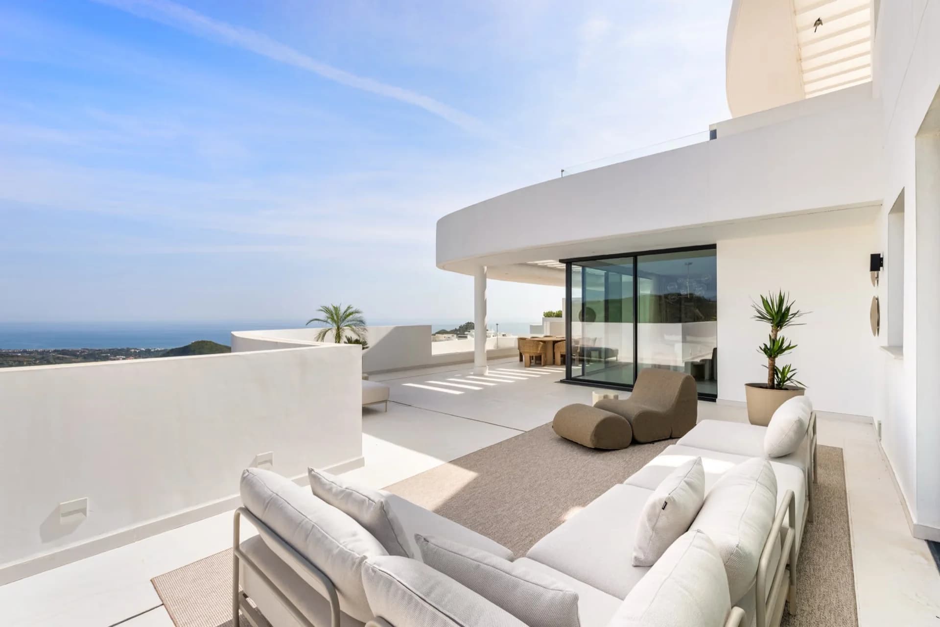 Licht villaterras met loungebank en zeezicht over de Costa del Sol